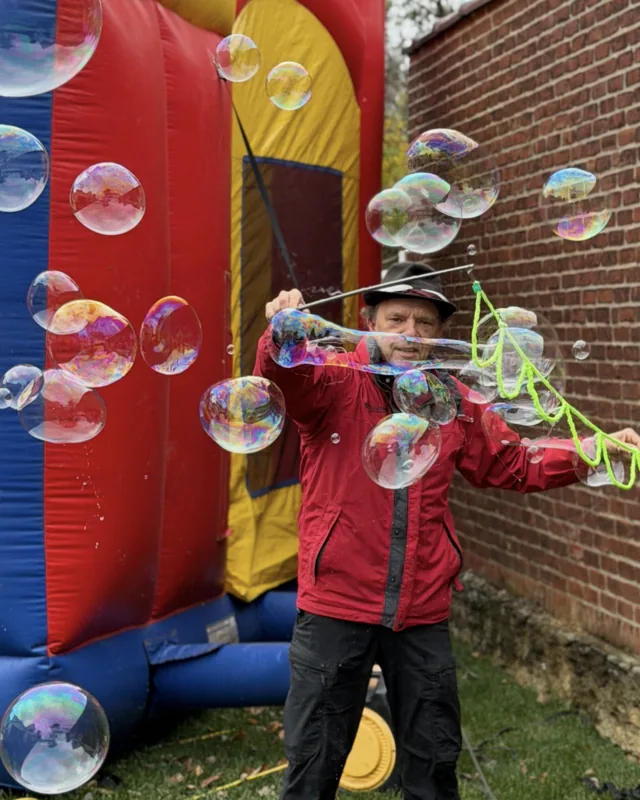Performer surrounding kids with giant bubbles
